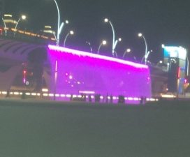 Magenta waterfall flowing off the elevated metro line into the canal.